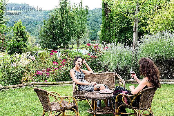 Frauen auf Korbstühlen im ländlichen Garten  Città della Pieve  Umbrien  Italien