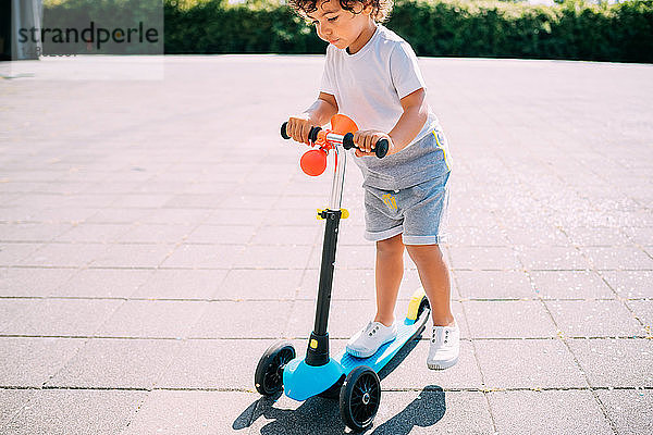 Kleinkind fährt Roller im Park