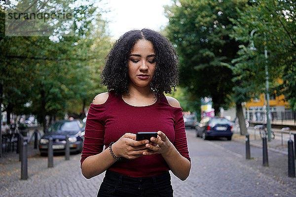 Junge Frau mit Mobiltelefon  Berlin  Deutschland