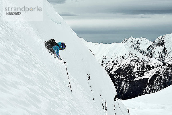 Männlicher Skifahrer rast den steilen Berghang hinunter  Alpe-d'Huez  Rhône-Alpes  Frankreich