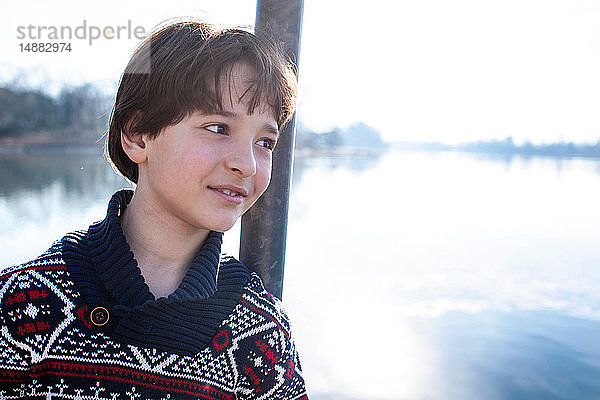 An einen Pfahl am See gelehnter Junge  Porträt  Comer See  Lecco  Lombardei  Italien