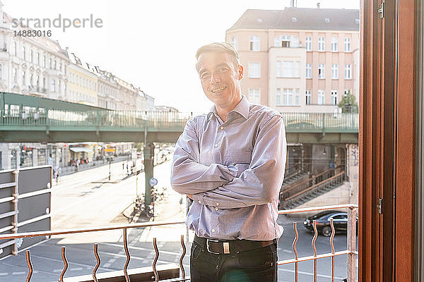 Geschäftsmann auf dem Balkon mit Blick auf die Straße  Berlin  Deutschland