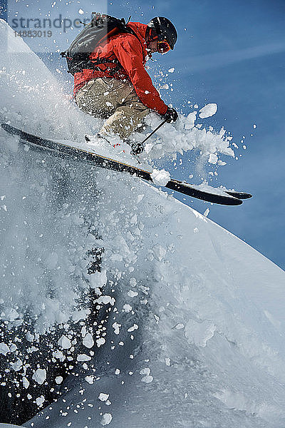 Männlicher Skifahrer beim Skifahren in der Luft  steiler schneebedeckter Berg  Alpe-d'Huez  Rhône-Alpes  Frankreich