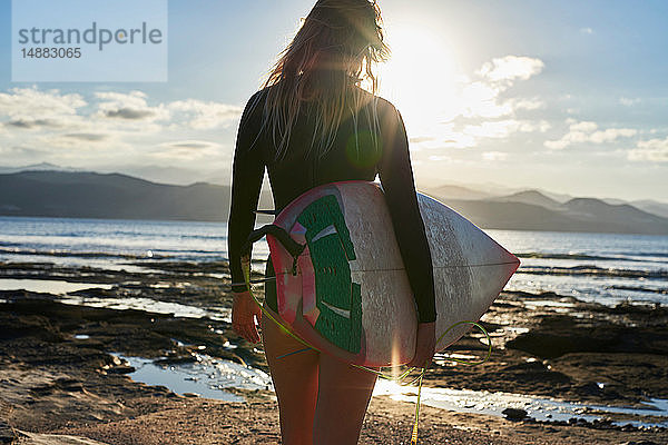 Surfer mit Surfbrett am Strand