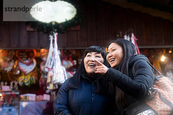 Mutter und Tochter beim Schaufensterbummel auf dem Weihnachtsmarkt  Freiburg  Baden-Württemberg  Deutschland