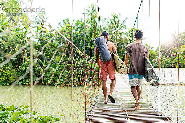 Männer mit Surfbrettern auf Seilbrücke  Pagudpud  Ilocos Norte  Philippinen