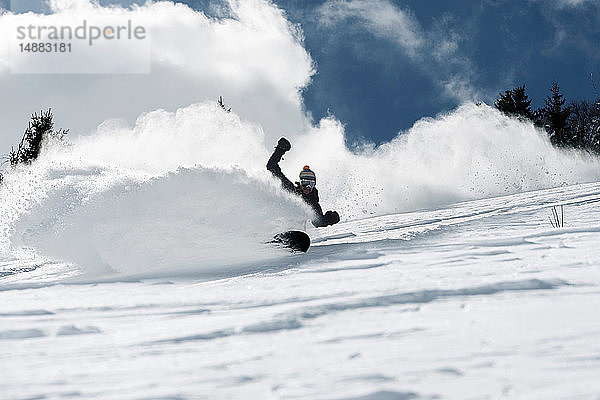 Männlicher Snowboarder rast den Berghang hinunter  Blick aus niedrigem Winkel  Alpe-d'Huez  Rhône-Alpes  Frankreich