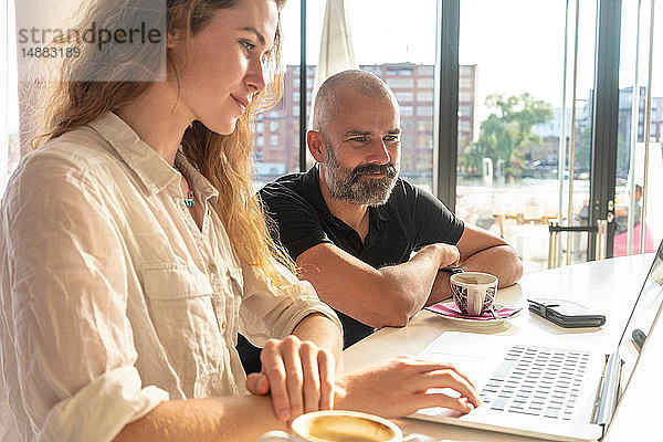 Zwei Unternehmer mit Laptop und Kaffee im Büro
