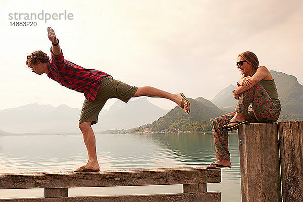 Junges Paar beim Balancieren auf dem Pier  See von Annecy  Annecy  Rhône-Alpes  Frankreich