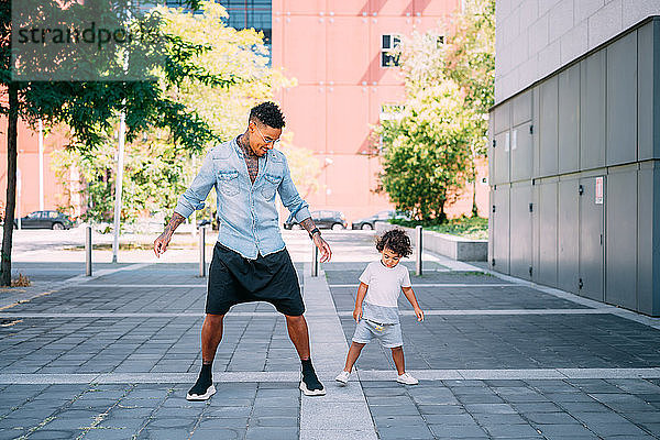 Vater und Sohn spielen auf dem Bürgersteig