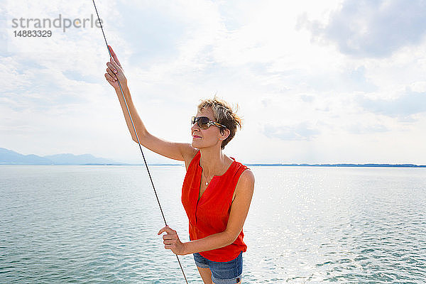 Reife Frau segelt auf dem Chiemsee  Bayern  Deutschland