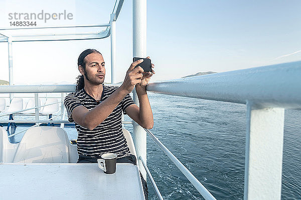 Mann auf Kreuzfahrtschiff beim Fotografieren