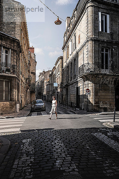 Straßenszene mit einer Frau  die die Straße überquert  Bordeaux  Aquitaine  Frankreich