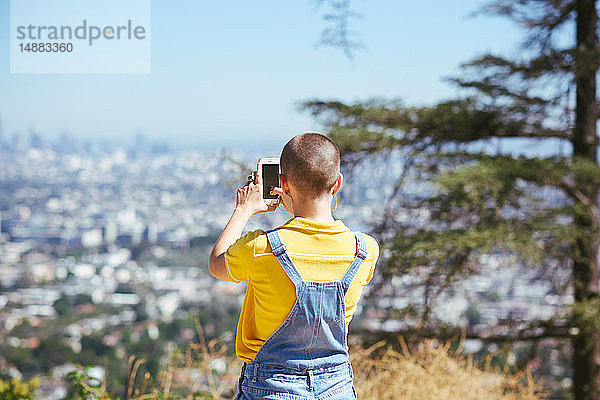 Teenager-Mädchen fotografiert Blick von der Stadtbildhügelspitze  Los Angeles  Kalifornien  USA