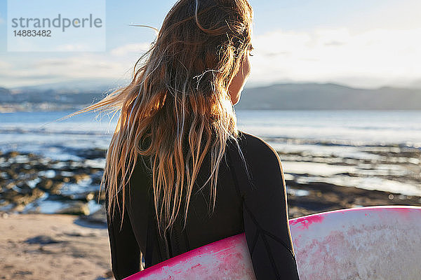 Surfer mit Surfbrett am Strand