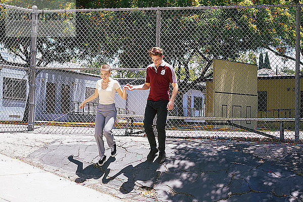 Junger Mann gibt einer Freundin im Park eine helfende Hand  Los Angeles  Kalifornien  USA