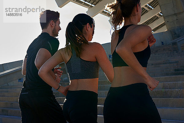 Freunde joggen Treppenstufen im Sportstadion hoch