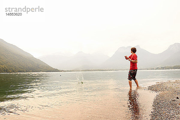 Junger Mann beim Steinschleifen im See von Annecy  Annecy  Rhône-Alpes  Frankreich