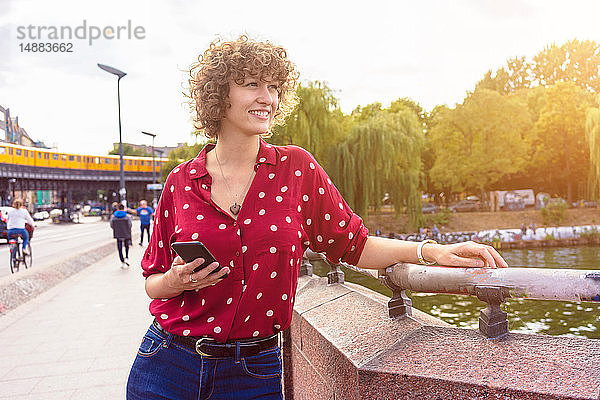 Junge Frau mit Handy auf Stadterkundung  Berlin  Deutschland