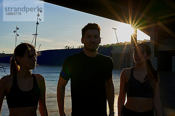 Freunde im Sportstadion bei Sonnenuntergang