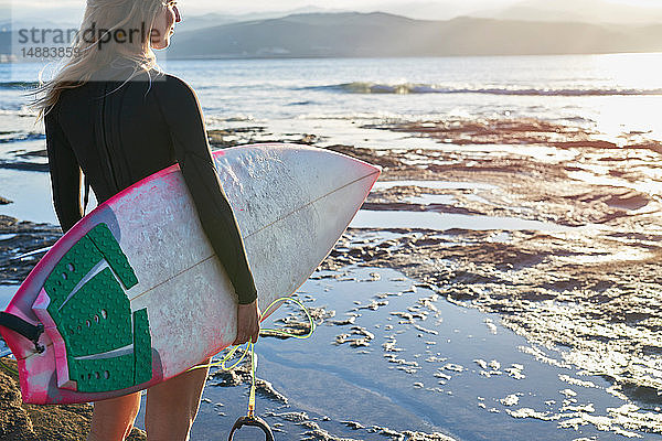 Surfer mit Surfbrett am Strand