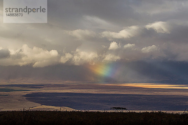 Landschaft mit Sturmwolken und regenbogenfarbigen Lichtstrahlen  Ngorongoro-Krater  Ngorongoro Conservation Area  Tansania
