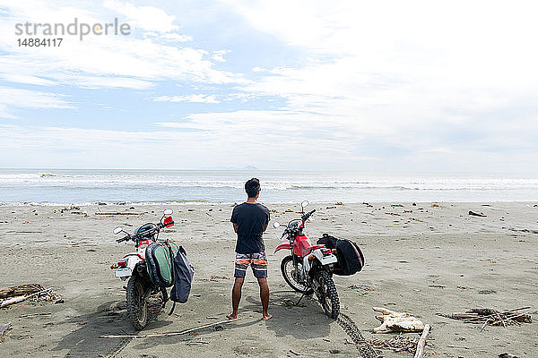 Motorradfahrer mit Surfbrett am Sandstrand  Abulug  Cagayan  Philippinen