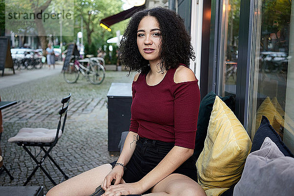 Junge Frau im Bürgersteig-Café  Berlin  Deutschland