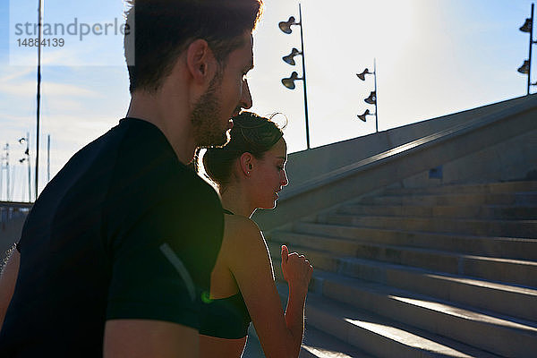 Freunde joggen Treppenstufen im Sportstadion hoch