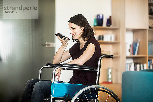 Frau im Rollstuhl mit Mobiltelefon