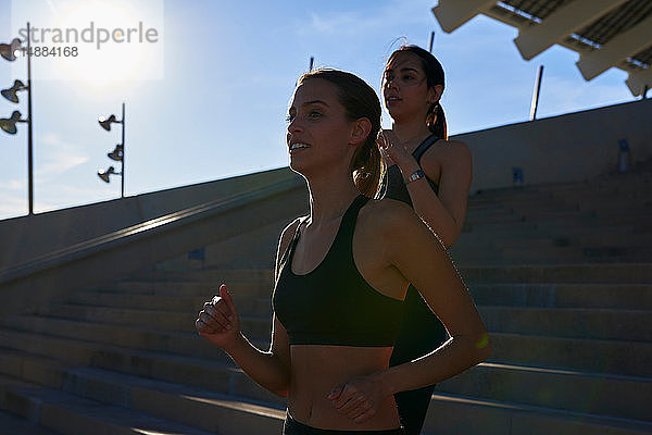 Freunde joggen im Sportstadion die Treppe hinunter