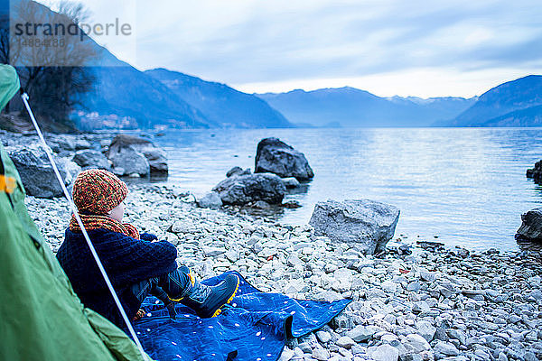 Junge sitzt vor dem Zelt am Seeufer  Comer See  Onno  Lombardei  Italien