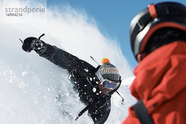 Männlicher Snowboarder rast den Berghang hinunter  Blick über die Schulter  Alpe-d'Huez  Rhône-Alpes  Frankreich