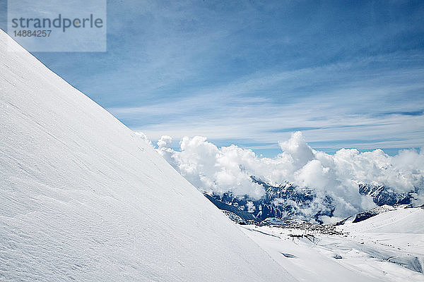 Schneebedeckte Landschaft mit niedrigen Wolken über den Bergen  erhöhte Ansicht    Alpe-d'Huez  Rhône-Alpes  Frankreich