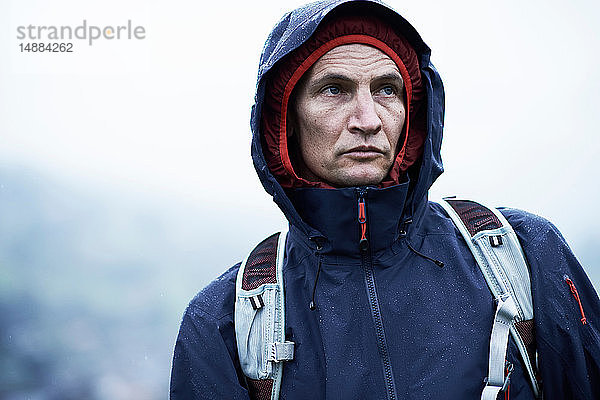 Männlicher Wanderer mit Kapuzenanorak bei Regen  Manigod  Rhône-Alpes  Frankreich