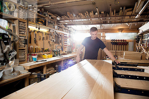 Handwerker  der in der Werkstatt Bretter aus Holz vorbereitet