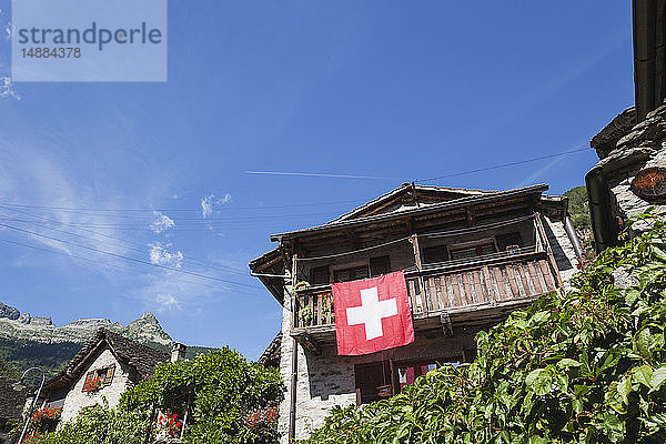 Schweiz  Tessin  Sonogno  typisches historisches Steinhaus mit Schweizer Fahne