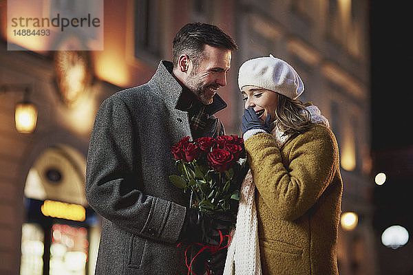 Mann schenkt seiner Freundin am Valentinstag einen Strauss roter Rosen
