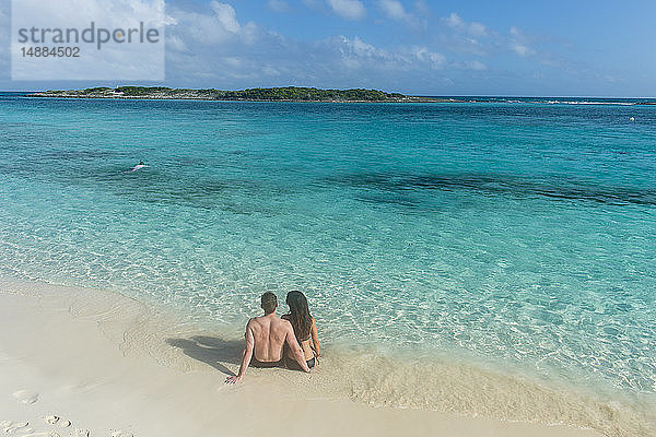 Karibik  Bahamas  Exuma  Ehepaar am weissen Sandstrand mit Blick auf das türkisfarbene Wasser