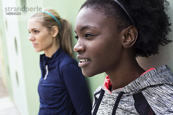 Zwei sportliche junge Frauen entspannen sich nach dem Laufen in der Stadt