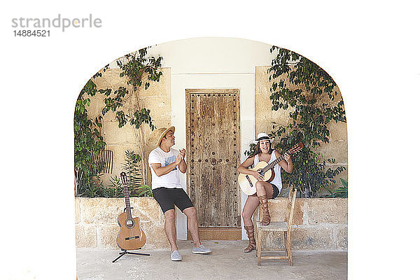 Mann und Frau spielen Gitarre auf der Veranda