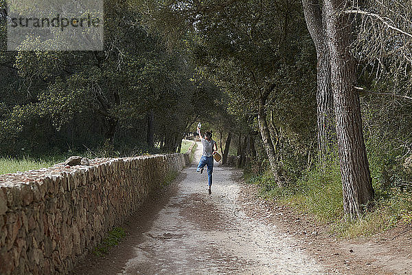 Spanien  Menorca  Rückenansicht einer glücklichen jungen Frau  die in die Luft springt
