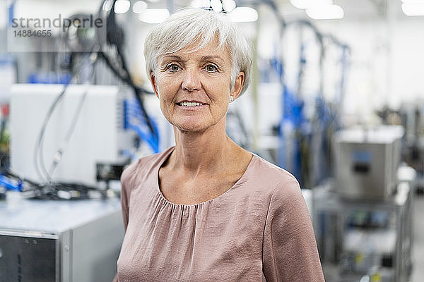 Porträt einer selbstbewussten älteren Frau in einer Fabrik