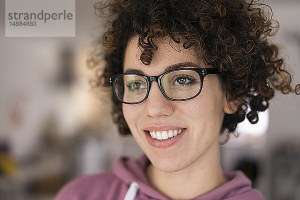 Bildnis einer jungen Frau mit lockigem Haar  die eine Brille trägt