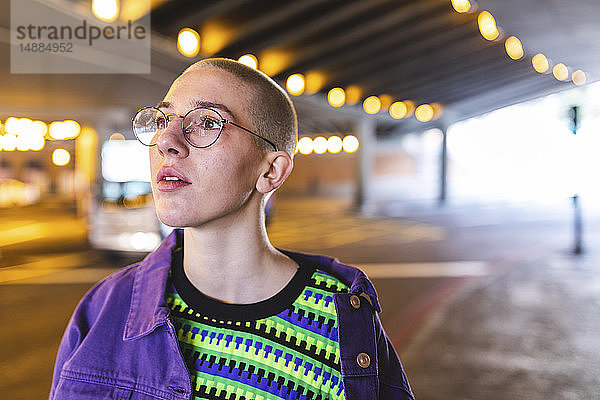 Porträt einer jungen Frau in der Stadt neben einer U-Bahn-Kreuzung