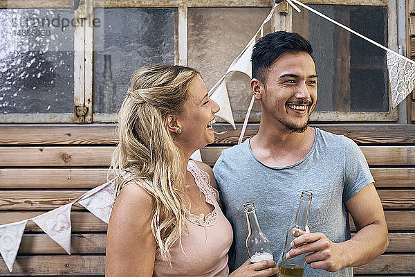 Freunde amüsieren sich auf einer Grillparty  trinken Bier