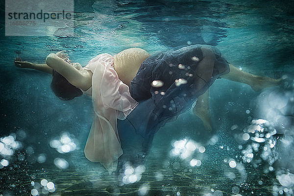 Schwangere Frau trägt Kleid unter Wasser
