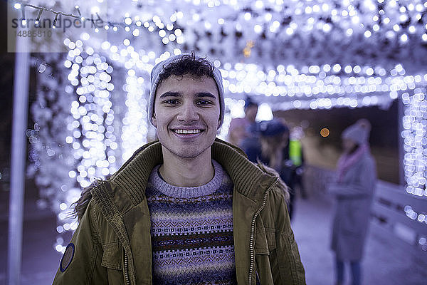 Porträt eines lächelnden jungen Mannes in Winterdekoration