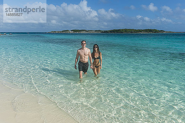 Karibik  Bahamas  Exuma  Ehepaar beim Spaziergang durch die türkisfarbenen Gewässer