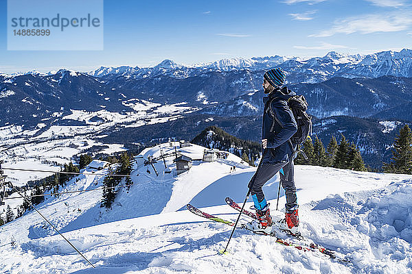 Deutschland  Bayern  Brauneck  Mann auf einer Skitour im Winter in den Bergen und genießt die Aussicht